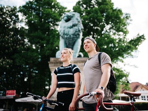 Radfahrende vor Flensburger Löwe