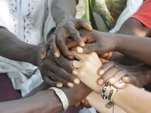 Auf diesem Bild sind viele schwarze und zwei weiße Hände zu sehen. Es ist das Logo des Vereins "Hand in Hand"