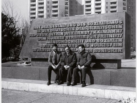 Der Bildhauer Lew Kerbel (Mitte) vor der Bronzestele mit der Inschrift von Erich Honecker.