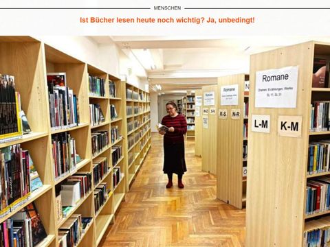 Benita Hanke in der Bibliothek mit einem Buch in der Hand