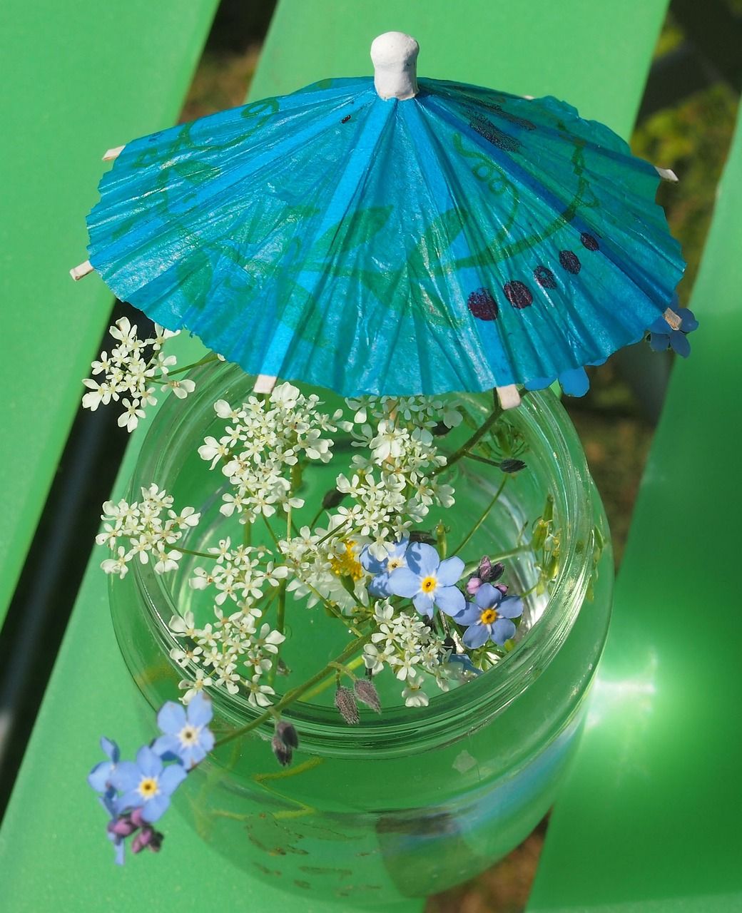 glas mit Wasser Sommerblumen Schirmchen