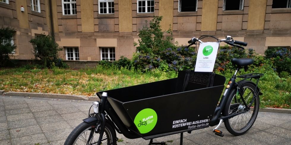 EIn schwarzes Lastenrad steht vor dem Rathaus Schöneberg auf dem Gehweg.