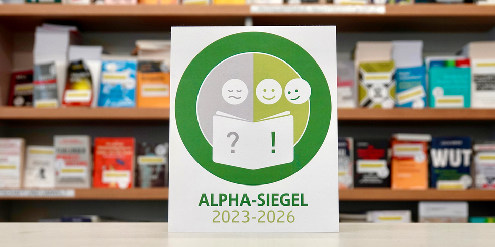 Logo "ALPHA-SIEGEL 2023-2026" vor Bücherregal