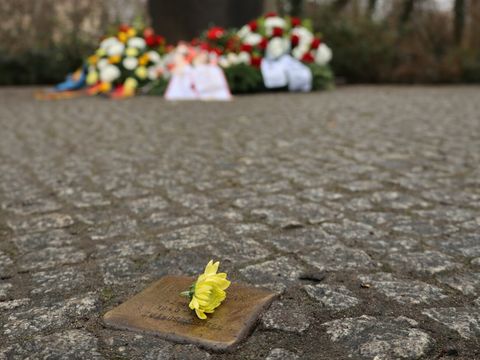 Symbolbild Stolperstein mit Trauerkränzen