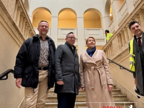 Bezirkstour Giffey - Herr Schmohl, Herr Igel und Fri Giffey stehen im Trreppenhaus des Peter Behrens Baus