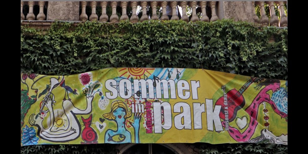 Banner mit bunten Figuren und dem Schriftzug Sommer im Park