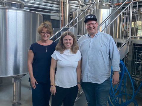 Clara Herrmann, Kathrin Klisch und Ben Pommer von BRLO vor den Braukesseln in der BRLO-Brauerei