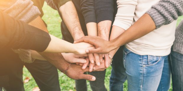 Freundesgruppe hält Hände in der Mitte zusammen