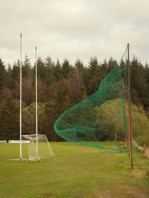 Fußball-Feld mit Tor und Fangnetz, beide Netze sind stark durch Wineinwirkung gewölbt