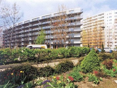 Erstes Niedrigenergiehaus in Marzahn, Blick auf einen Neubaublock im Vordergrund Begrünung