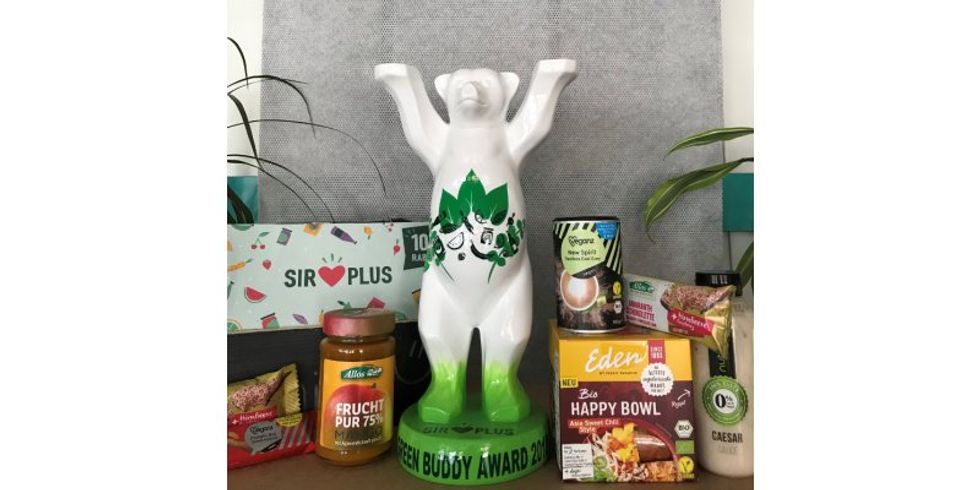 Green Buddy Award als Buddy Bär umgeben von Bio-Lebensmitteln