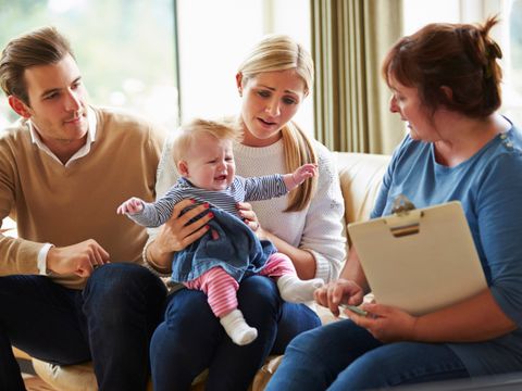 Sozialarbeiter besucht Familie mit kleinem Baby 