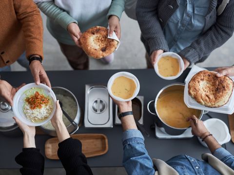 Freiwillige geben Essen an Menschen aus