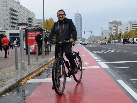 Bezirksbürgermeister Stephan von Dassel testet den neuen Radweg auf der Karl-Marx-Allee.