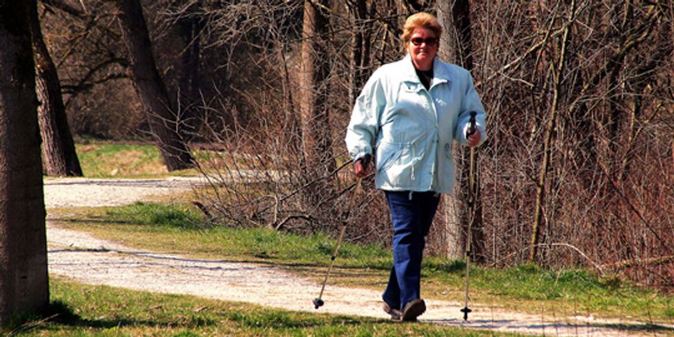 buehne_Frau walkt durch den Park bei Sonnenschein