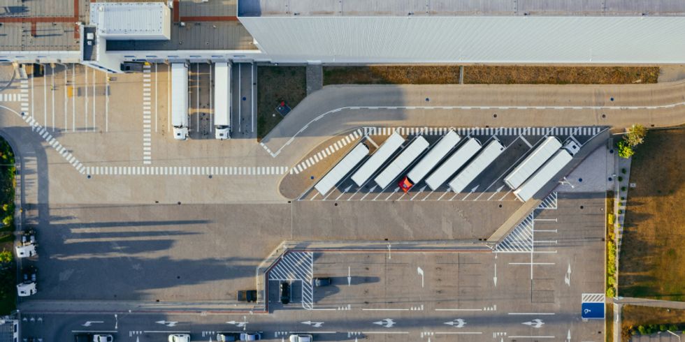 Luftbild von einem Parkplatz mit einigen LKWs