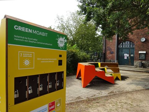 Solarhub und farbige Sitztreppen vor Backstein-Schule