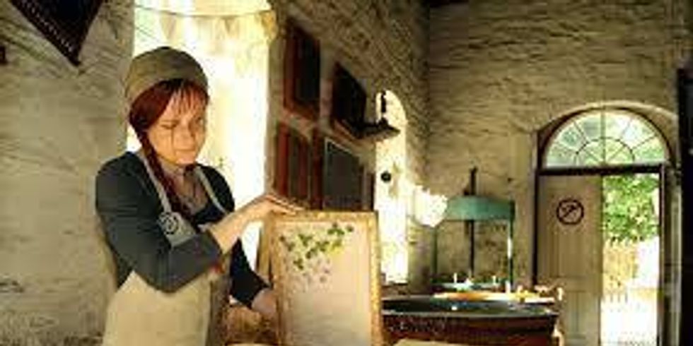 Frau schöpft von Hand Büttenpapier in der Papiermühle Niederzwönitz 