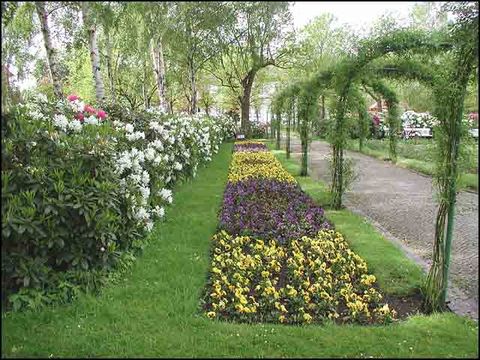 Rhododendren, Blumenrabatte und Rosenbögen
