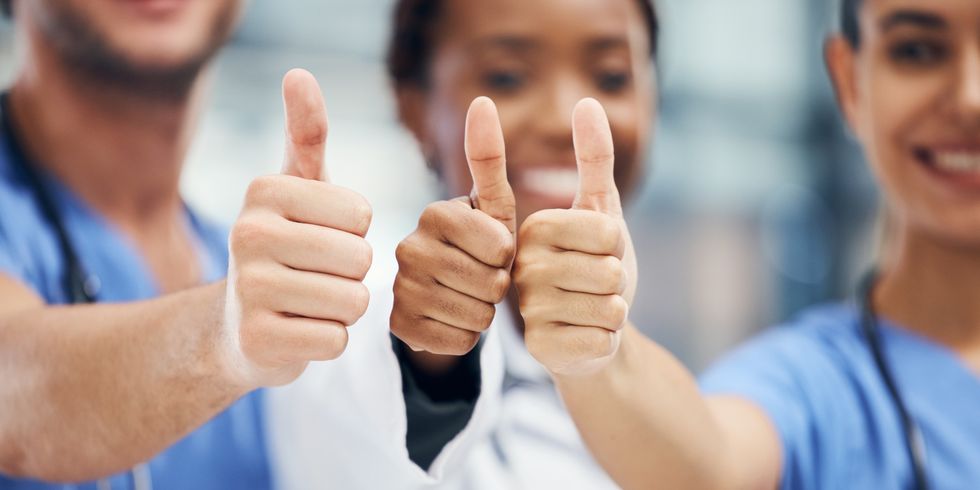 Ärzte und Krankenschwester halten drei Daumen hoch. Doctors, nurses or thumbs up hands in success, teamwork collaboration or trust with medical winner goal. Zoom on thank you, motivation and vote sign on man and support women in healthcare hospital