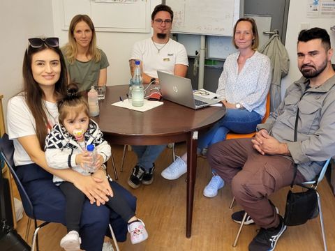 Sultan Özdemir mit Tochter Asya, Vanessa Wildner, Dennis Schreiber, Nicole Schmidt und Alper Özdemir in der Beratung des FamilienServiceBüros
