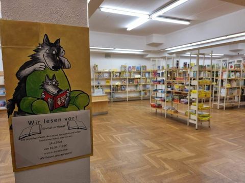 Foto der Biblitothek mit einem Schild "Wir lesen vor!"