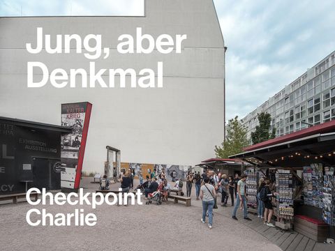 Bildvergrößerung: Blick auf eine der Brandmauern am Checkpoint Charlie. Die Freifläche davor ist heute mit Informations- und Verkaufsständen gefüllt. 