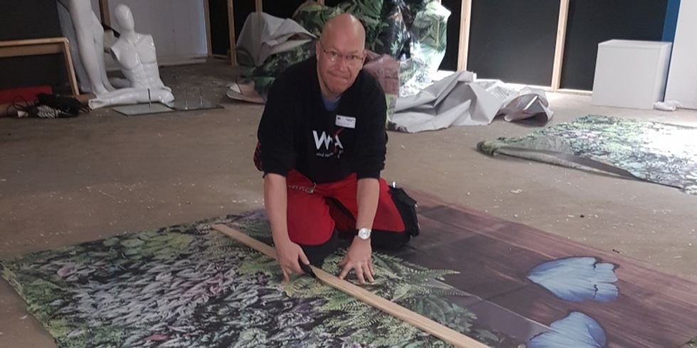 Der Straßenmeister der Wilmersdorfer Arcaden Carsten Wentzlaff hatte die Aufgabe, aus den 1000 Quadratmetern des Banners Stücke zu je zwei Quadratmetern zu schneiden.