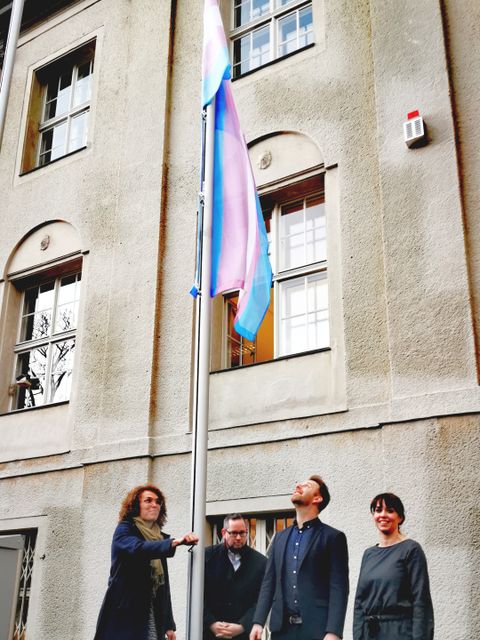 Bildvergrößerung: Bezirksbürgermeister Igel, die stellvertretende Bezirksbürgermeisterin Weingart sowie Bezirksstadträtin Dr. Leistner und Bezirksstadtrat Freier-Winterwerb hissen die Transgender Pride Flagge