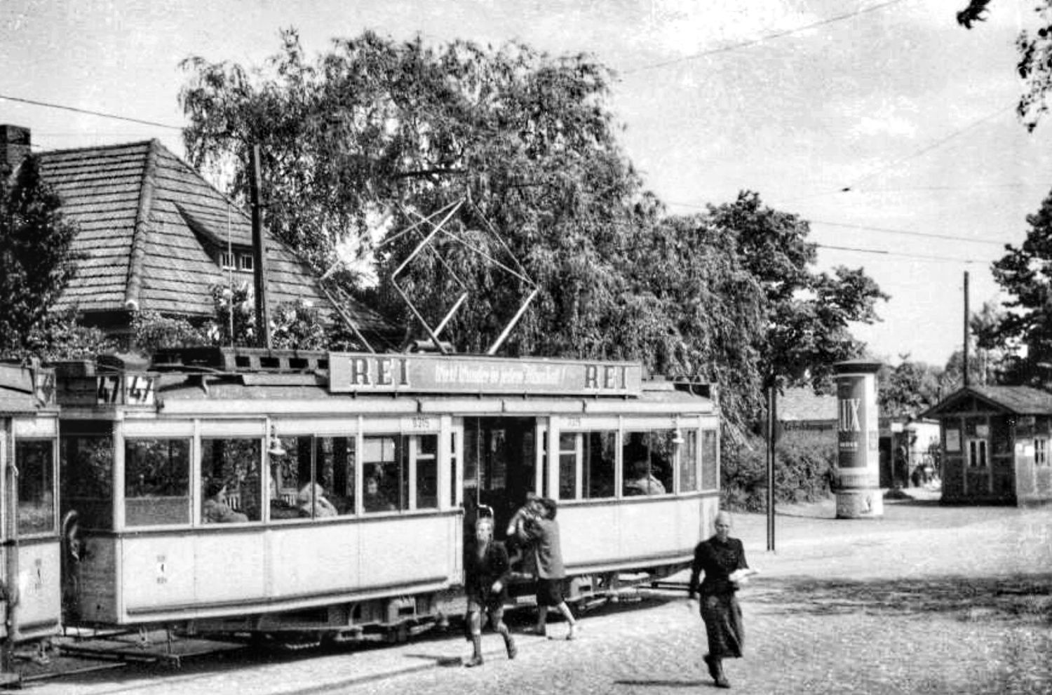 Historische Aufnahme von der Straßenbahnhaltestelle der Linie 47 in Rudow mit ein- und aussteigenden Passagier*innen