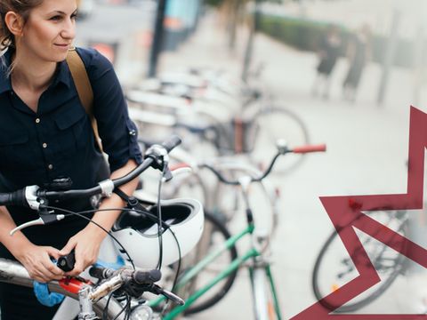 Junge Frau im blauen Hemd schließt ihr Fahrrad an