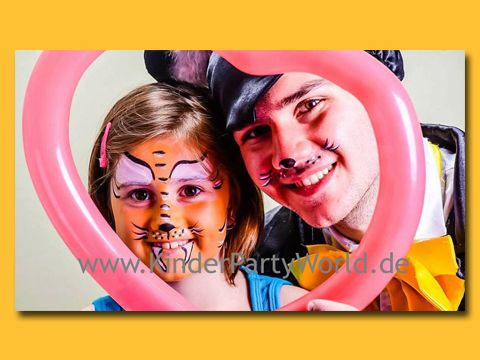 Lustig geschminkte Kinder schauen durch einen Schlauchluftballon