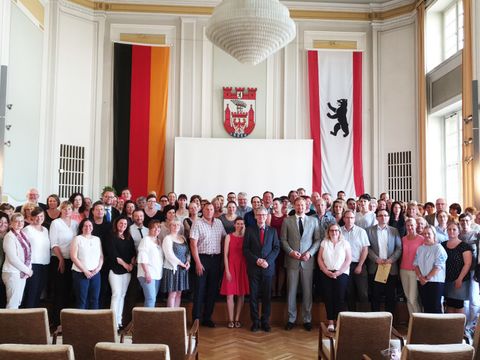 Bildvergrößerung: Gruppenfoto im Bürgersaal mit Bezirksbürgermeister Helmut Kleebank, dem Amtsleiter des Schul- und Sportamts Gregor Kempert und den geehrten Eltern