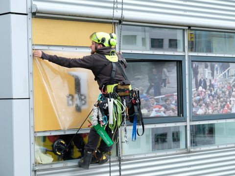 Fassadenkletterer bringen Fensterfolie an