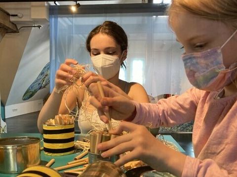 Bildvergrößerung: Zwei Kinder basteln Bienenhotels aus Blechdosen im Kindermuseum unterm Dach.