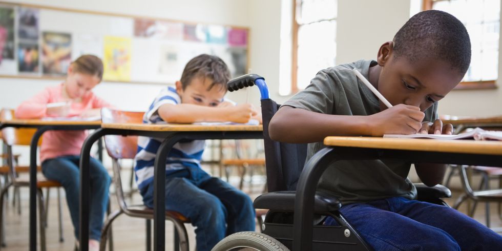 Kinder sitzen im Klassenraum und schreiben etwas