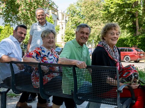 Bildvergrößerung: Bezirksstadtrat Aykal (links) sitzt gemeinsam mit Mitgliedern der Seniorenvertretung Steglitz-Zehlendorf auf einer der drei neuen Bänke