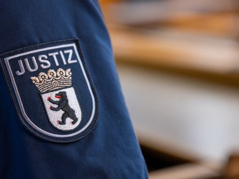 Wappen auf dem Arm einer Berliner Justizbeamtin