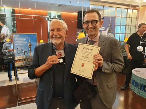 Erich John mit der Bezirksverdienstmedaille und Bezirksbürgermeister Stephan von Dassel mit der Urkunde