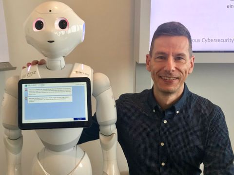 Mario Anton und der Robot Pepper mit Chatbot-App