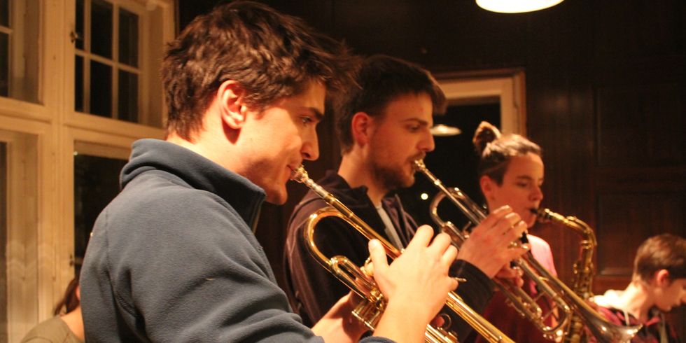 Zwei Trompeter und eine Saxophonistin spielen 