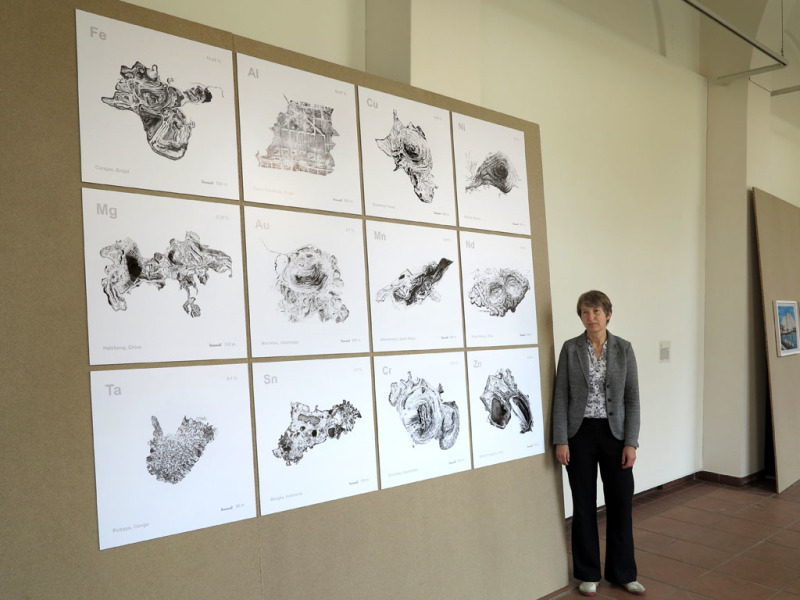 Die Künstlerin Ingeborg Lockemann steht vor ihrer Arbeit mit 12 schwarz-weiß Digitaldrucken