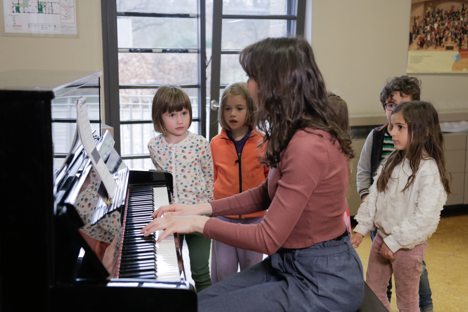 Kinder am Klavier hören Pianistin zu