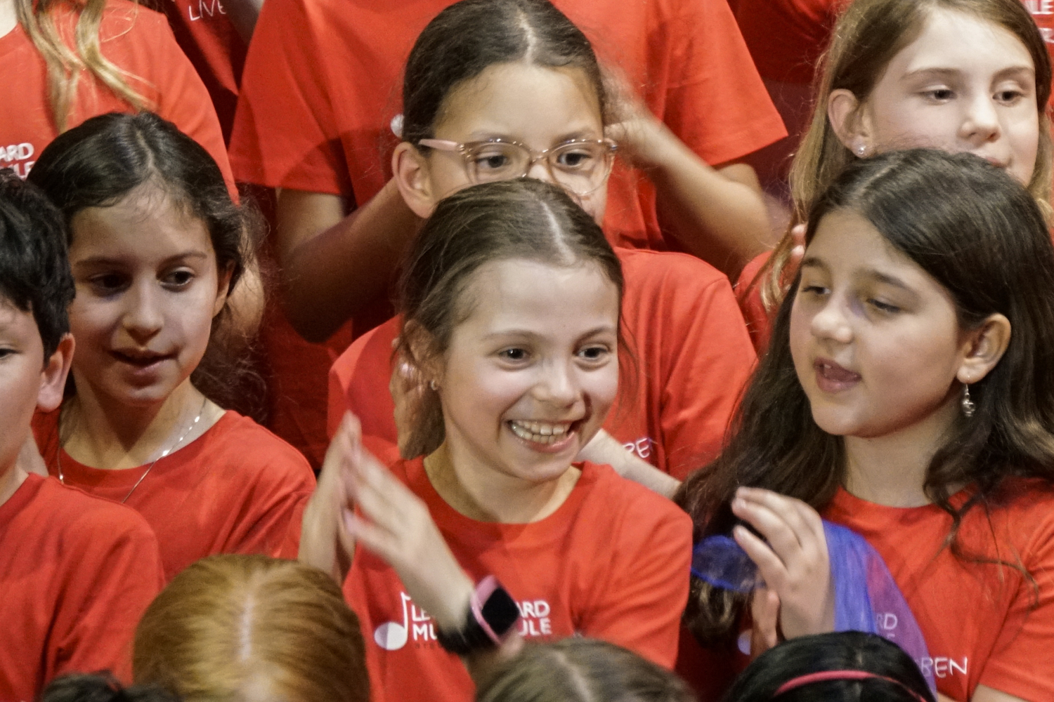 lachendes Mädchen in einer Gruppe von Kindern mit roten T-shirts