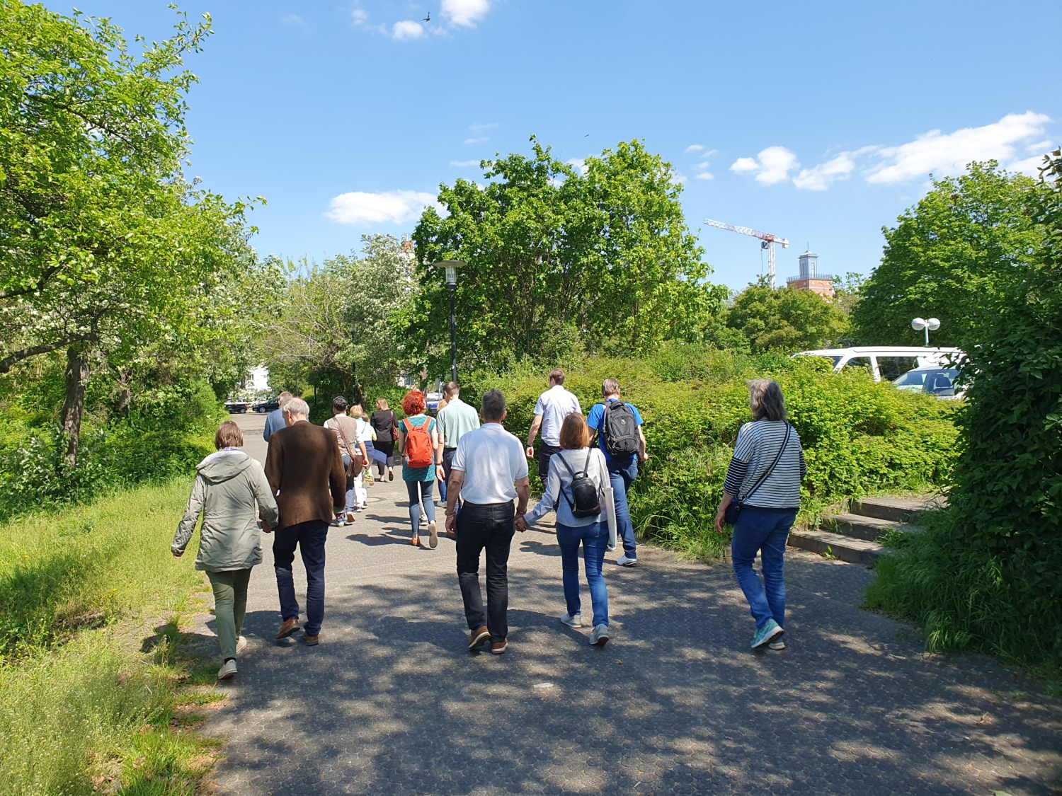 Mehrere Menschen gehen einen Weg in einem Park entlang