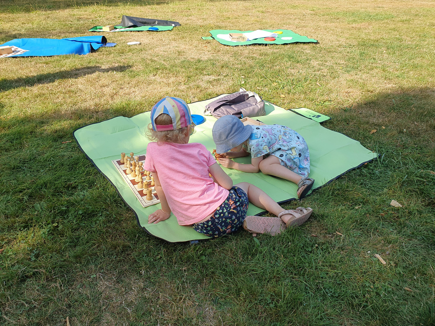 Kinder spielen Schach auf Decken