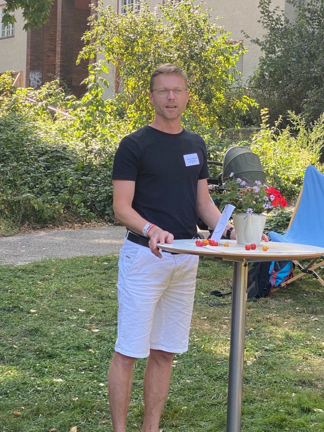 Mann steht an einem Stehtisch in einem Park