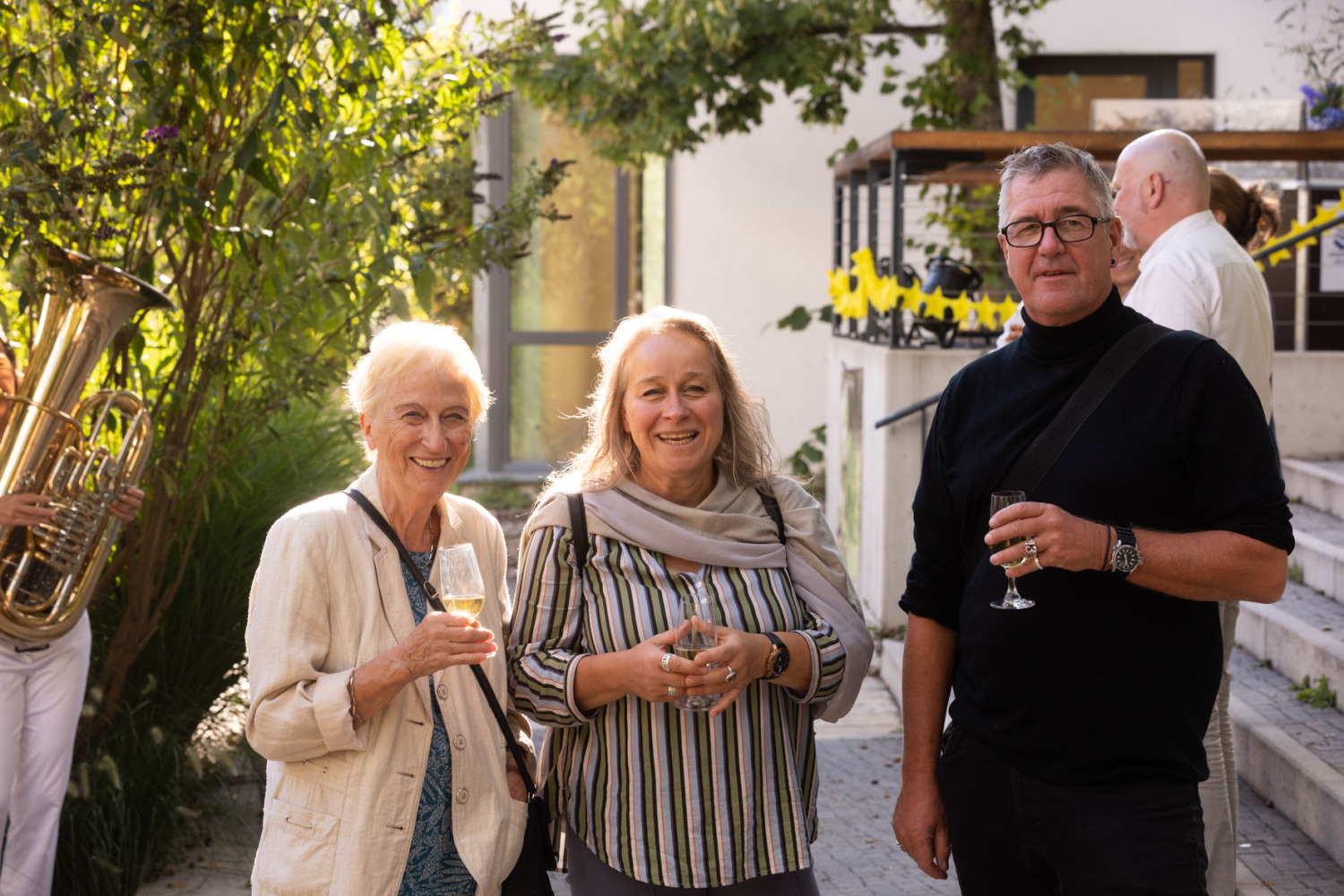 3 Personen blicken lächelnd in die Kamera