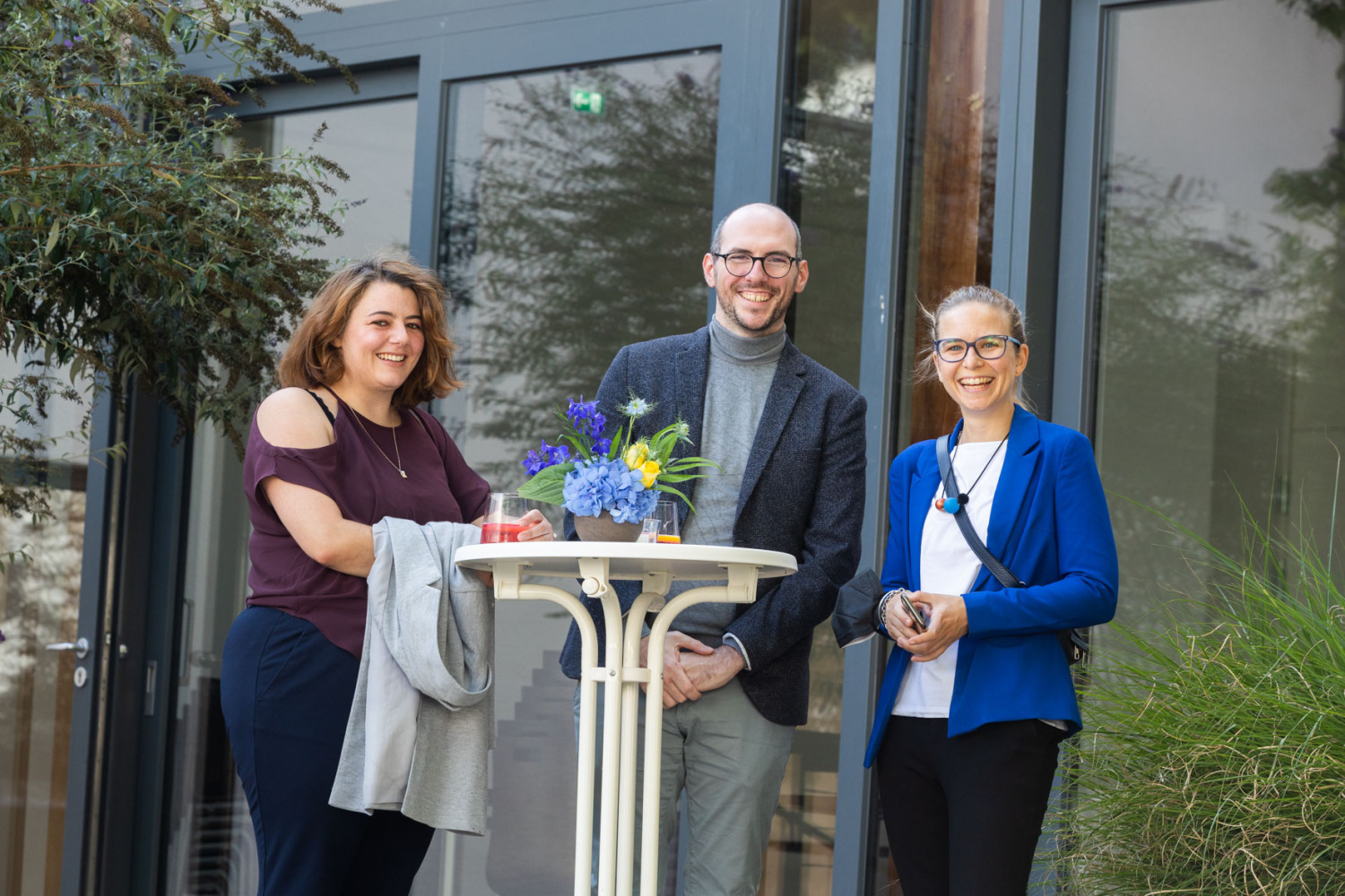 3 Personen am Stehtisch lachend