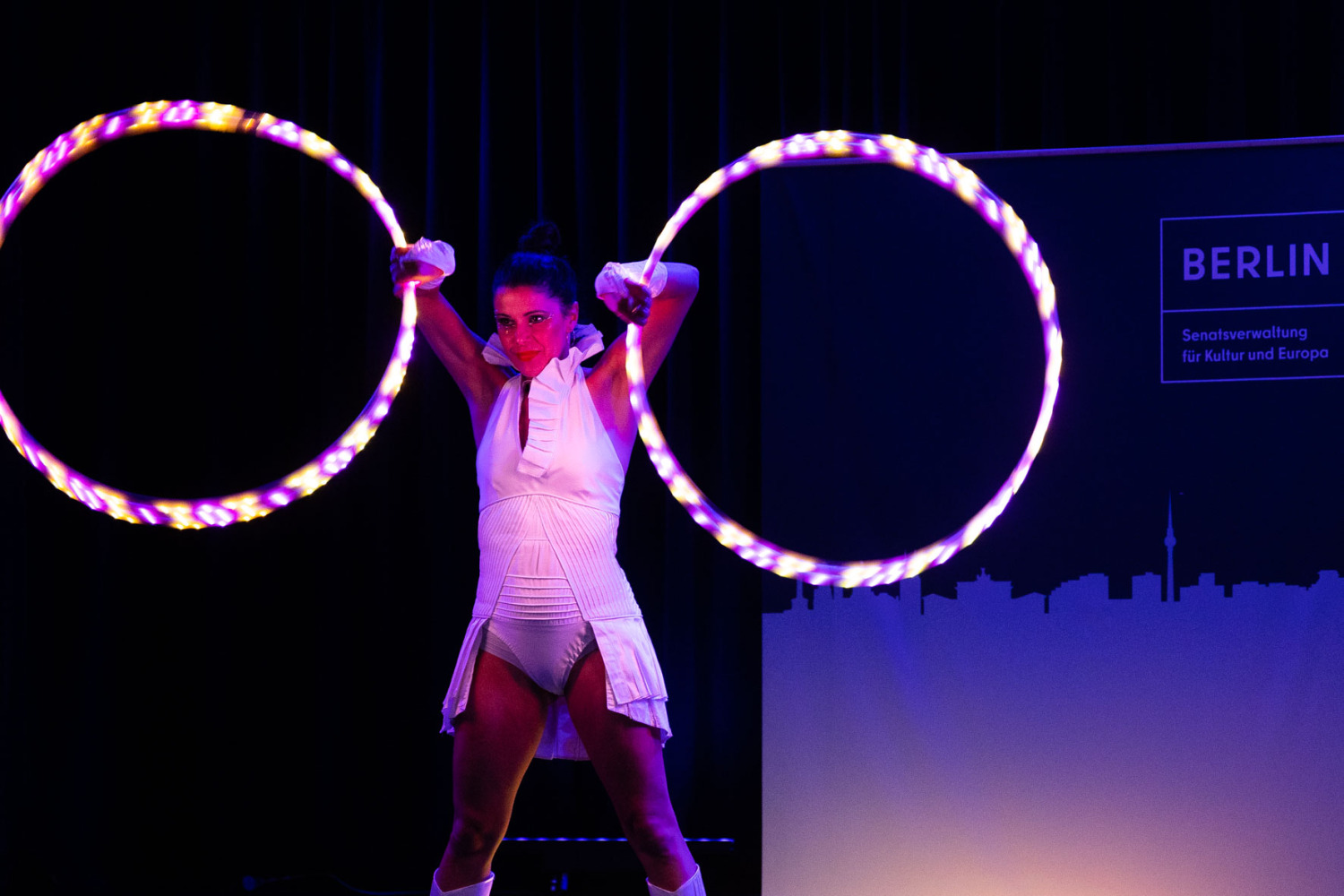 Frau schwingt leuchtende LED Ringe auf der Bühne